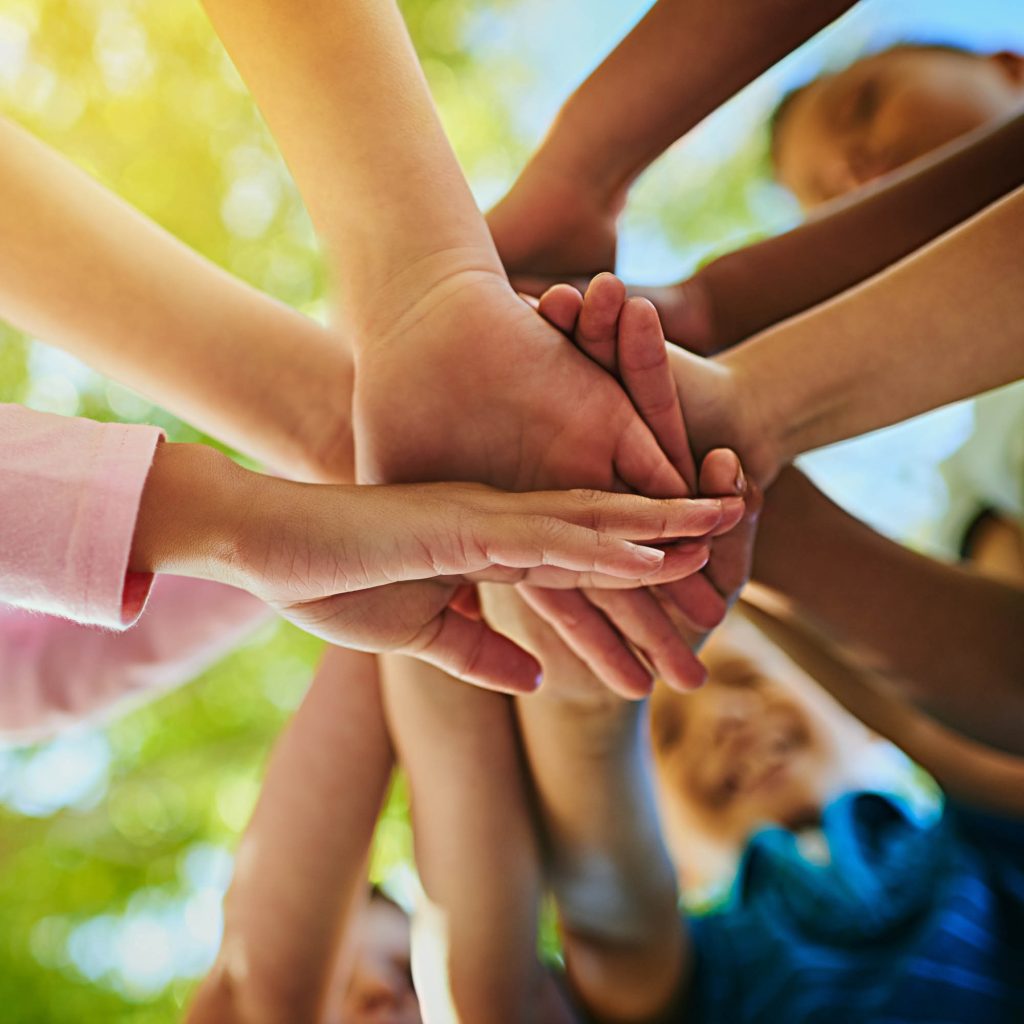 H&auml;nde von Kindern verschiedener Herkunft treffen sich in der Mitte des Bildes